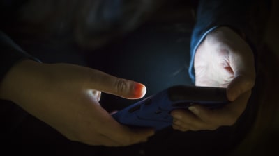 En person håller i en telefon i handen.