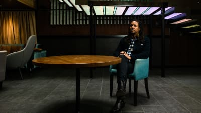 Colson Whitehead istuu sinisellä nojatuolilla.