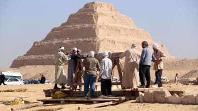 En grupp män arbetar vid en utgrävning i närheten av trappstegspyramiden i Sakkara.