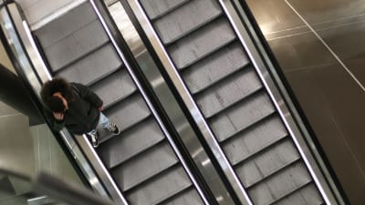 En man använder en rulltrappa.