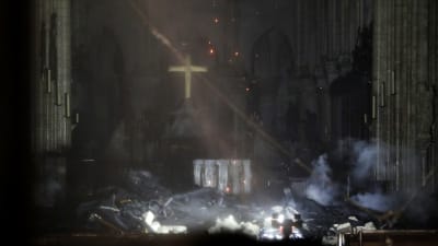 Insidan av Notre-Dame under branden. Golvet är täckt av bråte.