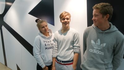 En flicka och två pojkar som besökte bokmässan 2019 i Helsingfors poserar tillsammans