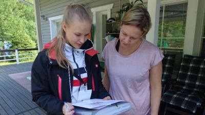 Janni Heikkinen och Tanja Sirviö kollar på dokument gällande avloppsvattensystem.