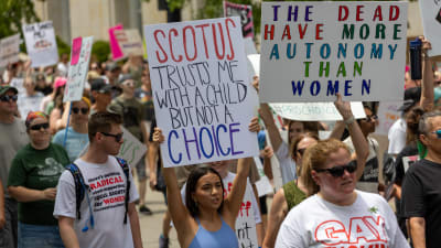 Kvinnor håller upp skyltar under abortdemonstration.