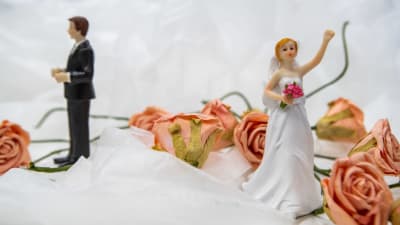Brudpar i plast omgivet av blommor