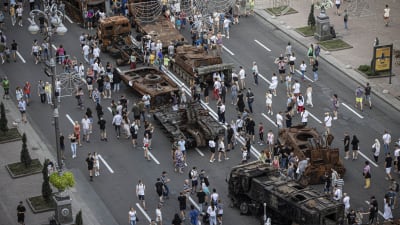 Ihmiset tutkivat Kiovaan esille tuotuja tuhottuja Venäjän sotilasajoneuvoja.