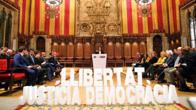 Barcelonas borgmästare Ada Colau talar inför en banderoll med texten Frihet, rättvisa, demokrati