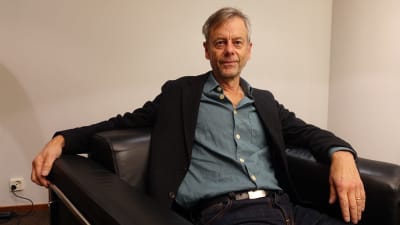 Författaren och journalisten Mats-Eric Nilsson sitter bakåtlutad i en fåtölj