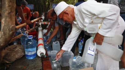 Invånare i Kapstaden, som lider av vattenbrist, fyller vattensflaskor med vatten från en bergskälla