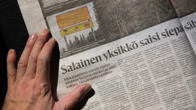 Foto av Helsingin Sanomats artikel den 16.12.2017 med en hand vilande på tidningen.