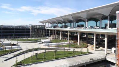 En bild från en flygplats i Turkiet - på bilden syns gräs och gråa byggnader. 