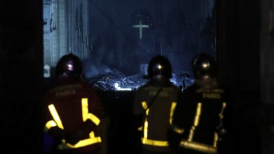 Brandmän vid Notre-Dame, som brinner.