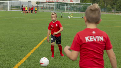 Jalkapalloa harrastava William Haapanen treenaa kaverinsa Kevin Eroman kanssa Espoonlahden urheilupuiston kentällä.