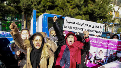 Afghanska kvinnor demonstrerar med plakat på en gata i Kabul. Texten på plakatet lyder: "Vi är det hungriga folkets röst".