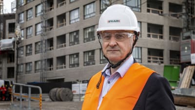 Mika Katajisto fotograferad iklädd skyddsutrusning på en byggarbetsplats. 