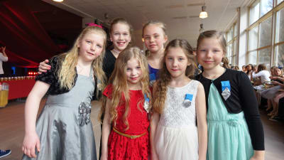 Flickorna från Sannäs visar upp sina vackra festklänningar och frisyrer.