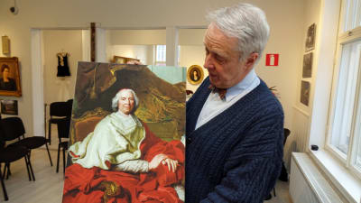 Bernt Morelius hå¨ller upp ett porträtt av kardinal de Fleury