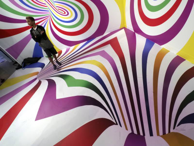 Man står i färgglad optisk illusion på Candytopia.