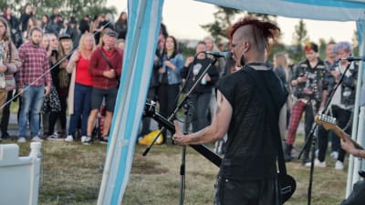 En bassist spelar framför en publik inne i ett tält
