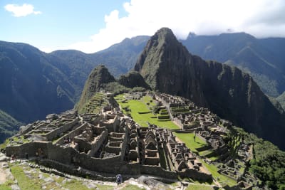 Ruinerna i Machu Picchu med berg i bakgrunden.