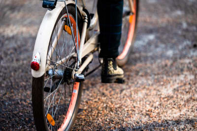Pyörä auringonvalokeilassa sepelin päällystämällä tiellä.