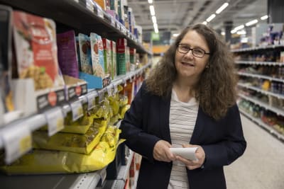 Kristiina Nieminen poserar mellan hyllorna i ett snabbköp. 