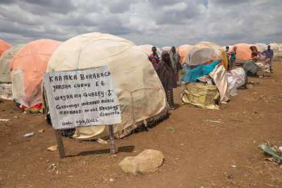 Puolipallon muotoisia majoja ja pakolaisia somalailaisella pakolaisleirillä Baidoan kaupungissa keskipäivän kuumuudessa. 