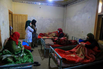 Två kvinnliga anställda står bland sina patienter på en klinik i Kabul som erbjuder vård för drogberoende kvinnor och barn. Verksamheten finansieras med hjälp av internationella donationer. 