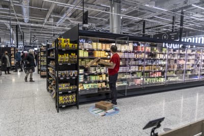 Työntekijä hyllyttää tuotteita Kolmisopin K-Citymarketissa.