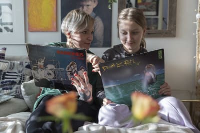 Mira och Miranda sitter i soffan och tittar på lp skivor. 