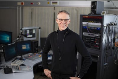 Redaktören Bertil Blom i studiomiljö, ser leende in i kameran 
