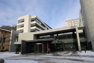 Åbo rättscenter, en vit byggnad med stora fönster, fotograferat en solig vinterdag med snö på marken.