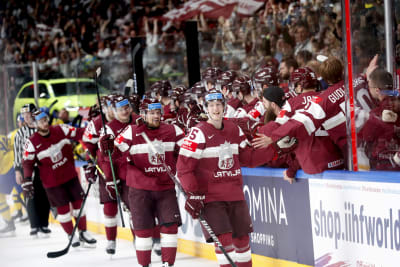 Lettiska spelare jublar framför bänken.