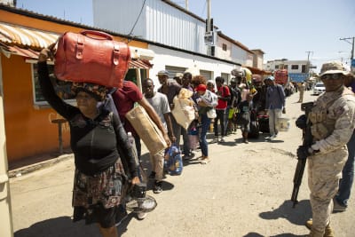 Haitiska medborgare bär sina tillhörigheter och är på väg att lämna landet.