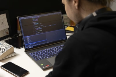 En anställd vid Nitro Games sitter vid en dator och skriver kod.