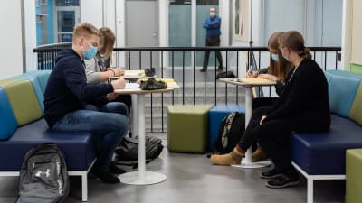 Opinto-ohjaaja Sari Heinonen seuraa, kun 9.-luokkalaiset Siiri Ylösmäki, Vilma Rautava ja Topias Kaapu tekevät matematiikan tehtäviä.