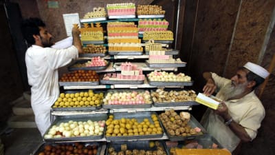 Försäljare i Pakistan radar upp sötsaker inför festhögtiden Eid al-Fitr.