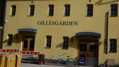 En cykel och en gul byggnad.