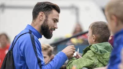 Tim Sparv skriver autografer.