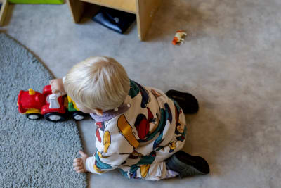 Ett barn leker på golvet.