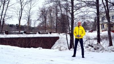 Mansperson står i vinterlandskap.