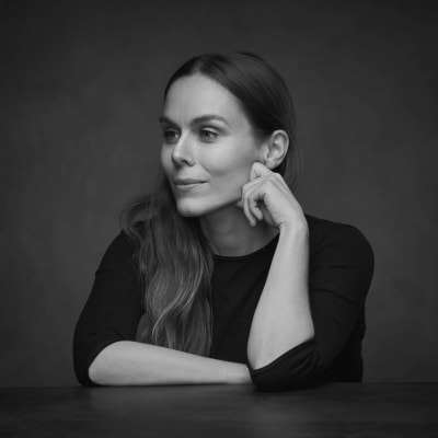 Ett svartvitt porträtt av en svartklädd kvinna med långt hår (Ulrika Nettelblad, vinnare av Solveig von Schoultz-tävlingen 2023)