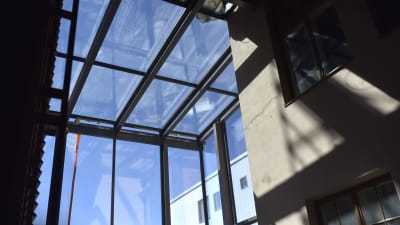 en vy ut ur ett stort fönster i övre hörnet av ett högt rum