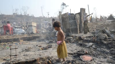 Barn bland nerbrända hus.