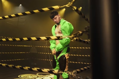Käärijä, iklädd ljusgröna kläder, står i en boxningsring, och ser in i kameran.