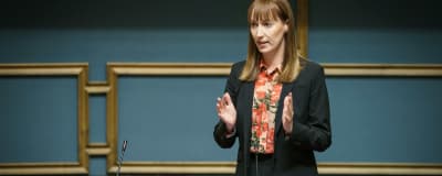 SDP:n kansanedustaja Eveliina Heinäluoma puhuu seisten omalla paikallaan eduskunnan istuntosalissa.