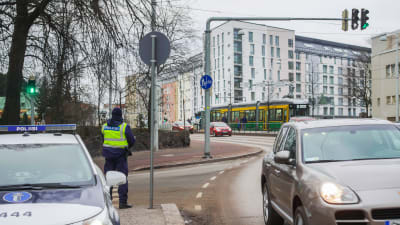 Polis övervakar trafiken vid Mechelingatan i Helsingfors.