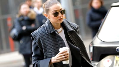 Supermodellen Gigi Hadid anländer till domstolshuset med en kaffekopp i handen och solglasögon på sig.