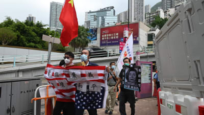 Pro-kinesiska demonstranter i Hongkong håller i en nidbild av talman Nancy Pelosi samt en uppochnedvänd USA-flagga.