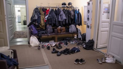 Tamburen på Prostgården i Borgå. På golvet ligger massor med skor och väskor, i knagget hänger rockar.